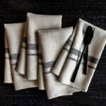 Four table handkerchiefs along with a fork and knife