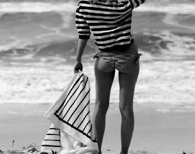 A girl holding a mat, standing near beach